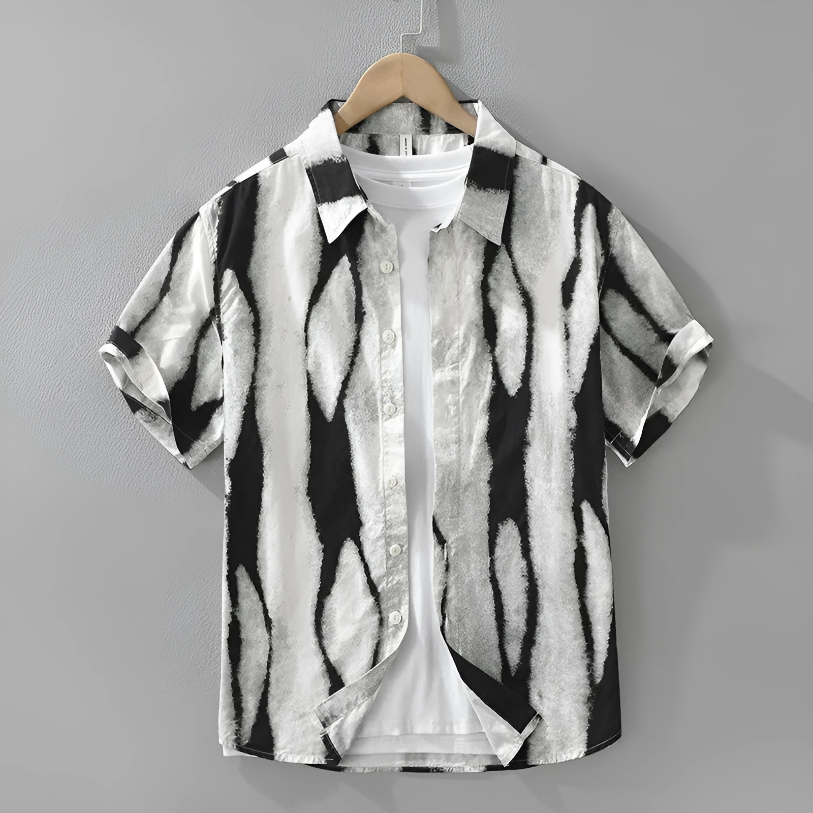 A man wearing a black and white striped loose-fit cotton cardigan-style short sleeve shirt.
