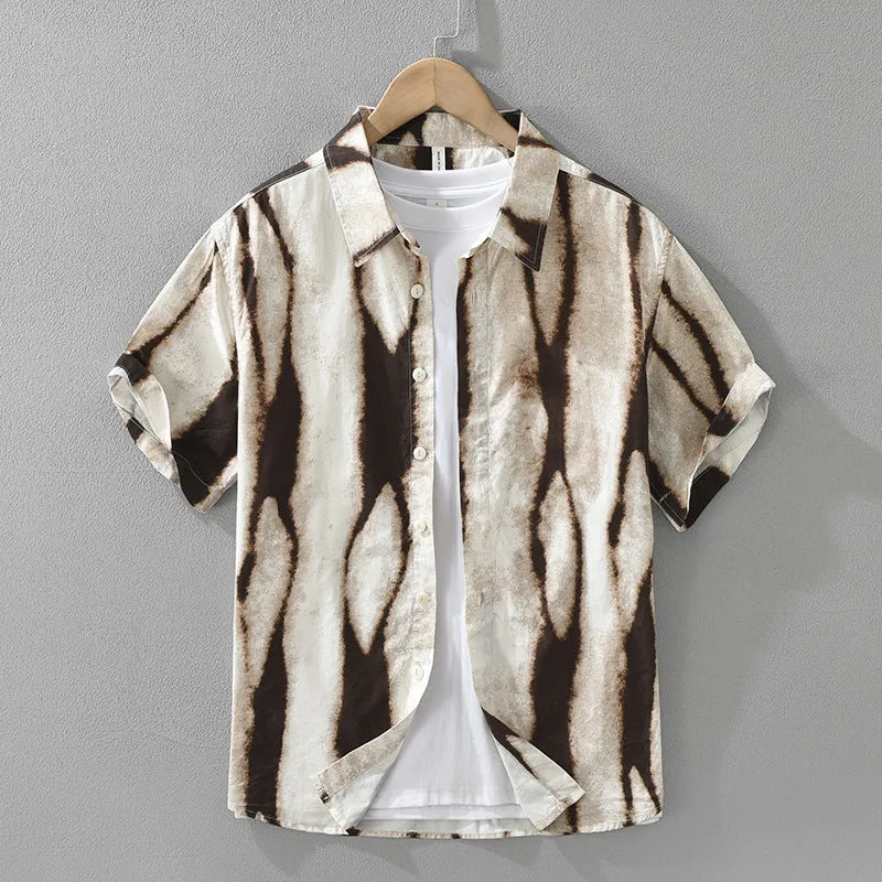 A man wearing a black and white striped loose-fit cotton cardigan-style short sleeve shirt.