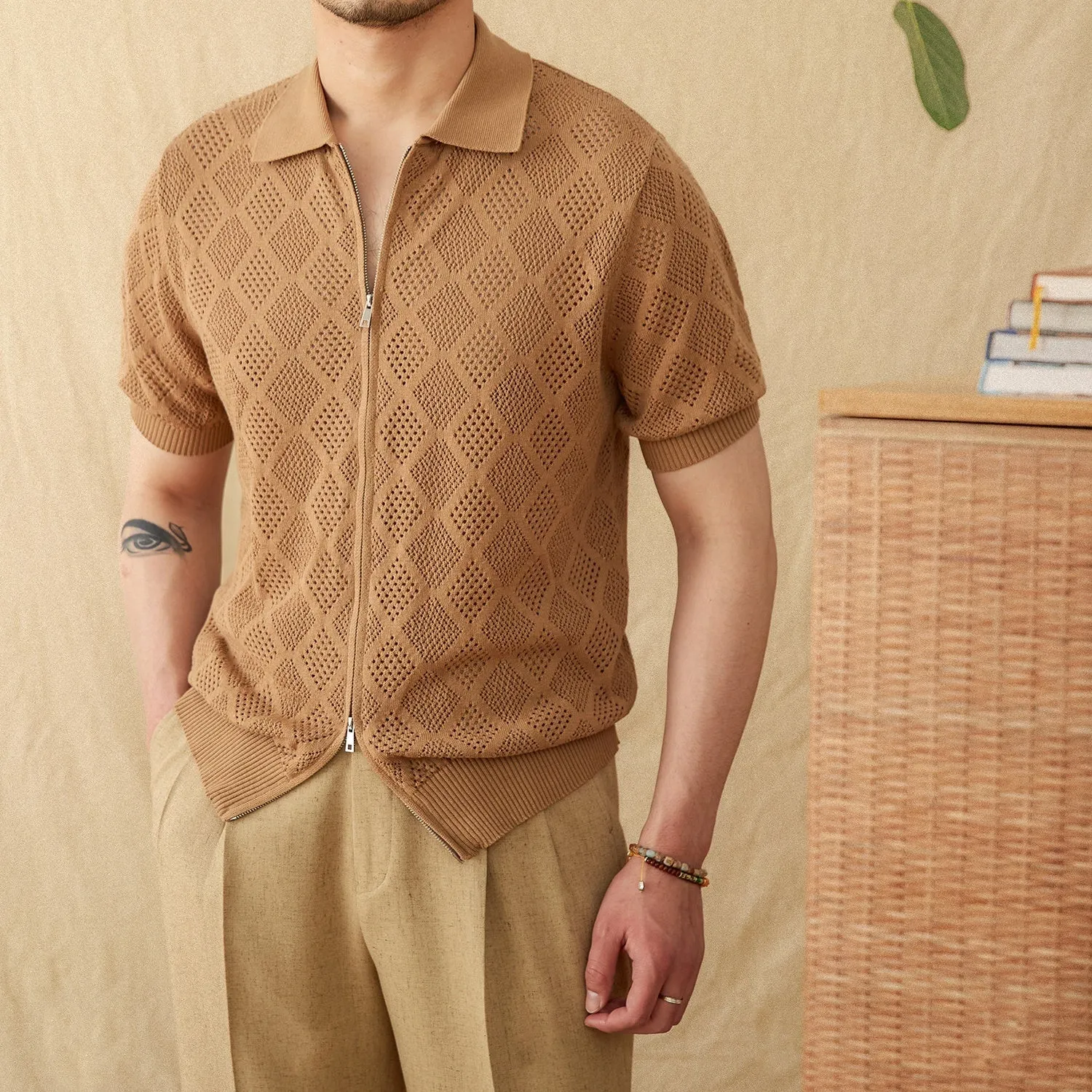 Light brown short sleeve cotton cardigan with a front zipper and lapel collar laid flat.
