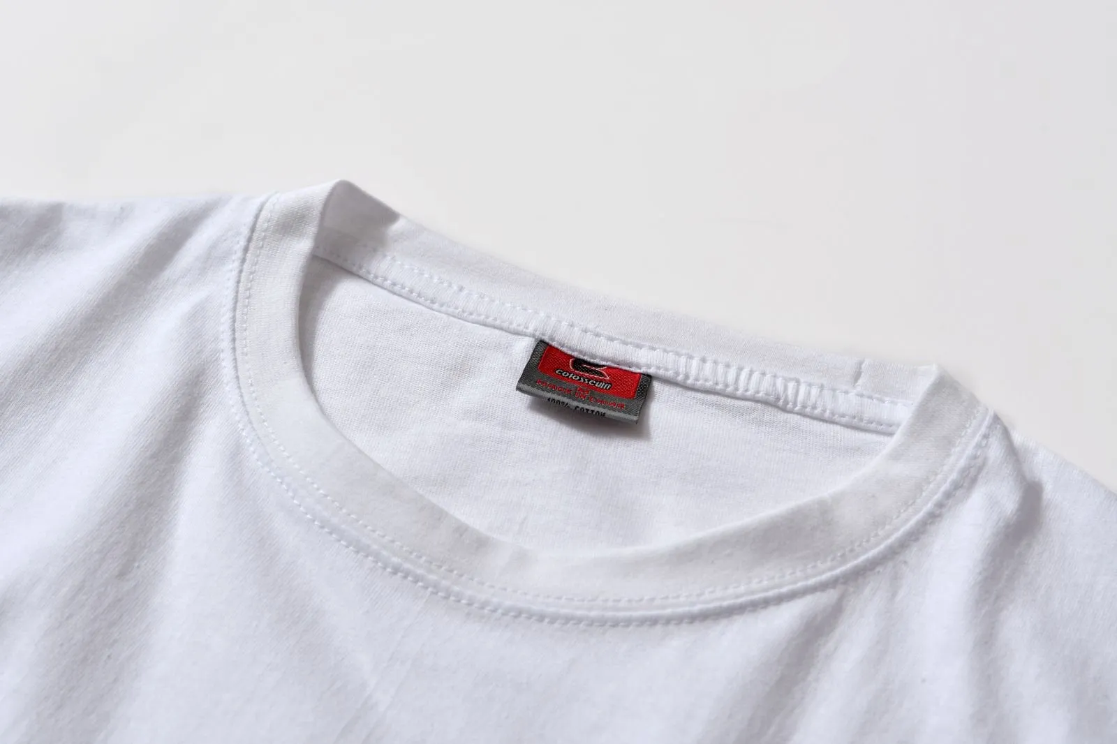 White cotton pullover overalls with short sleeves and a round neck, shown on a hanger.