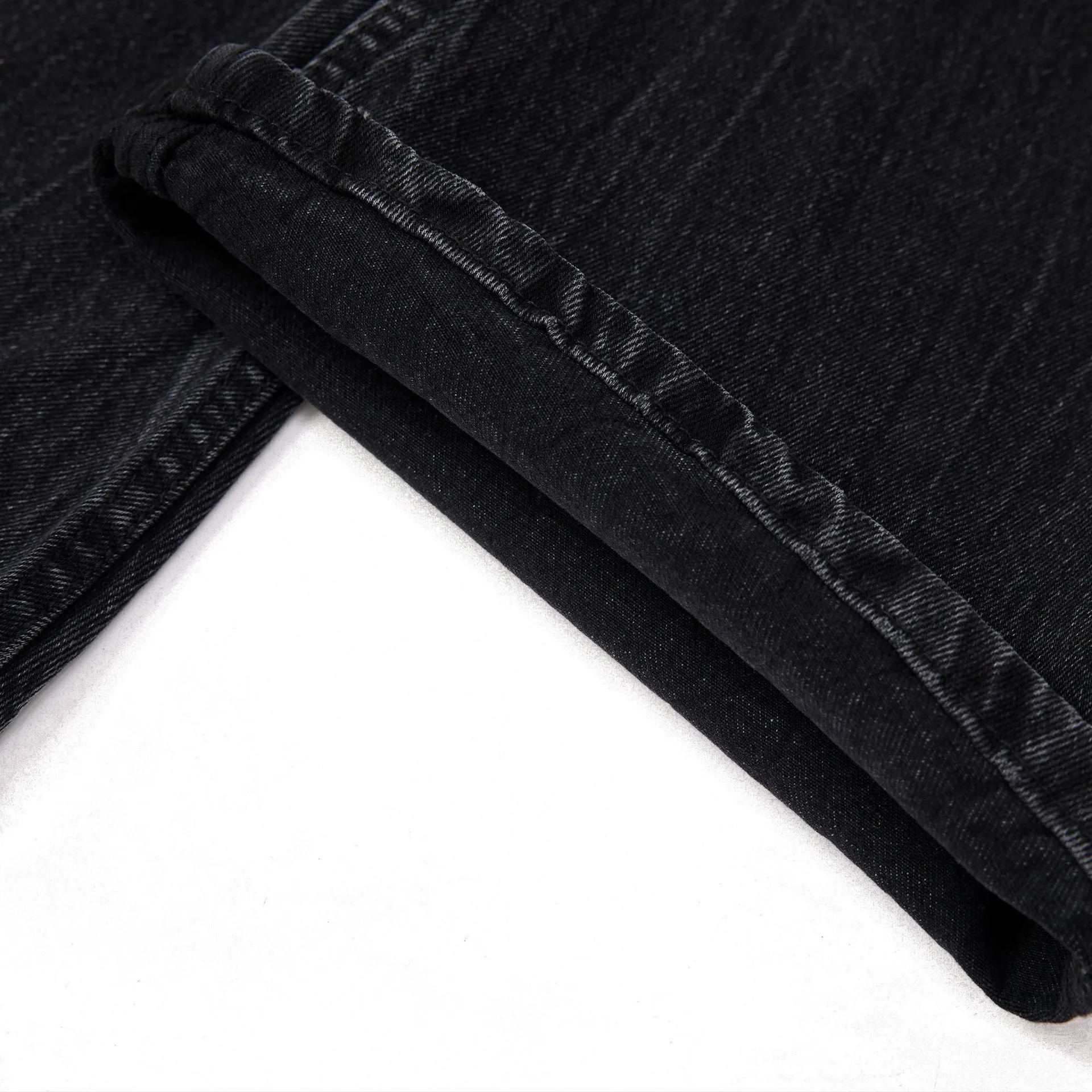 Black straight-leg jeans with lightning crack distressing pattern on knees and thighs