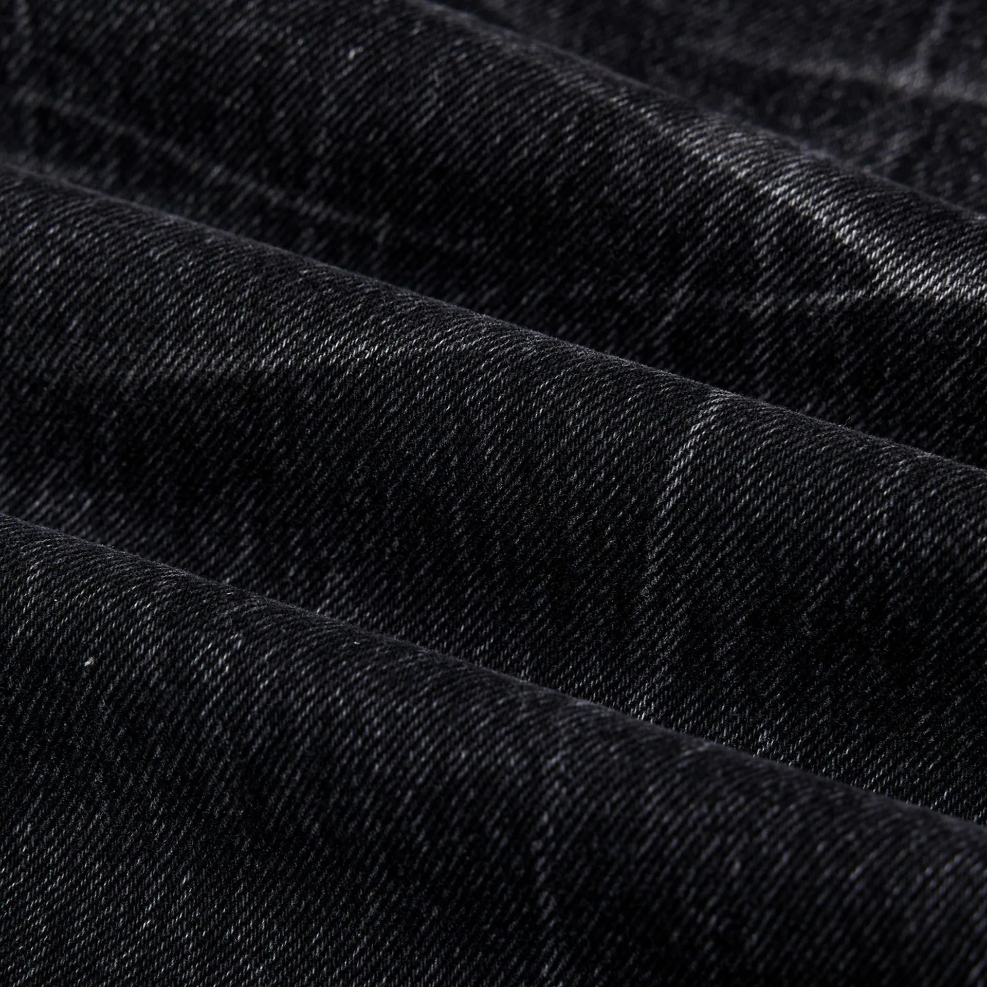 Black straight-leg jeans with lightning crack distressing pattern on knees and thighs