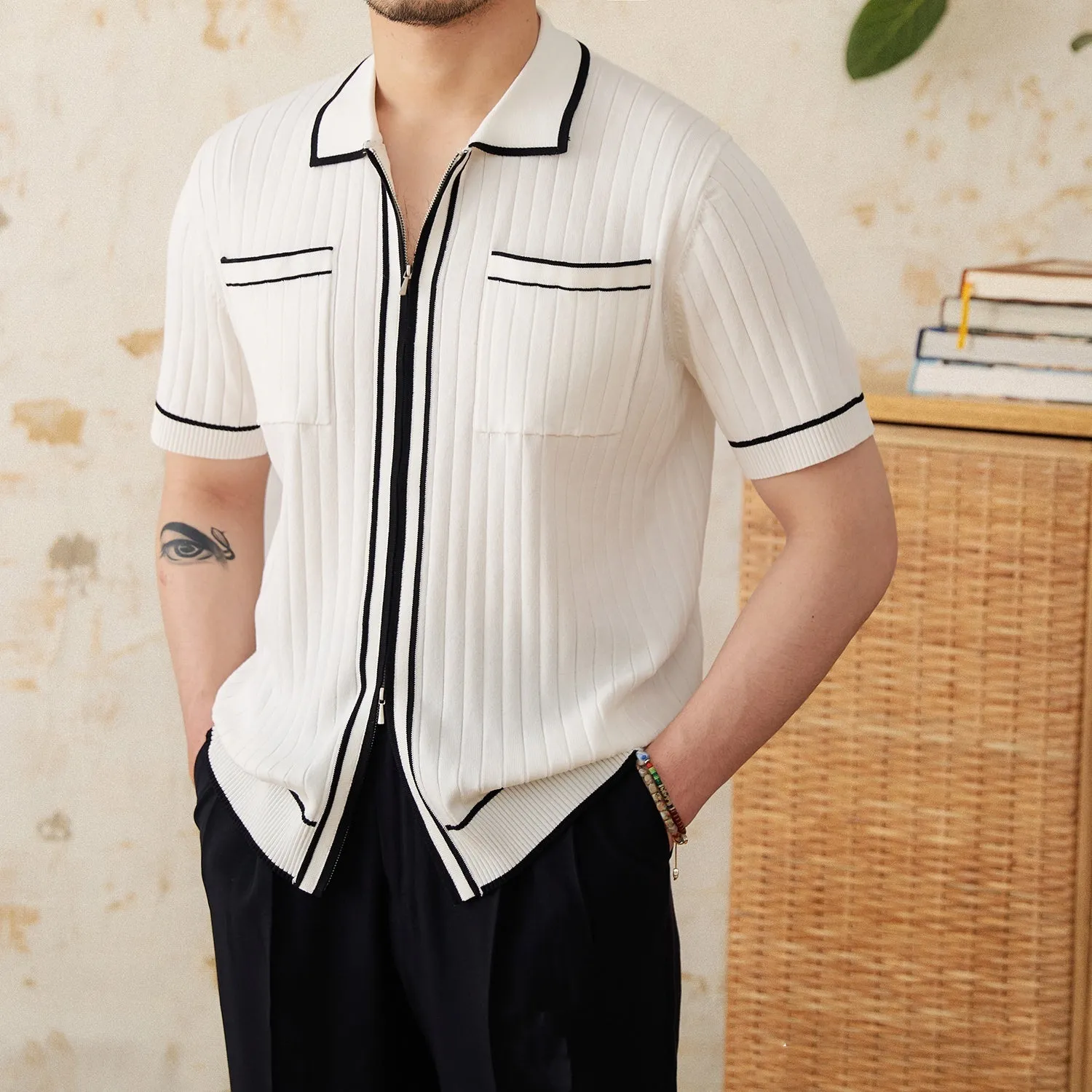 Slim fit black knitted polo shirt with a lapel collar and short sleeves on a hanger.