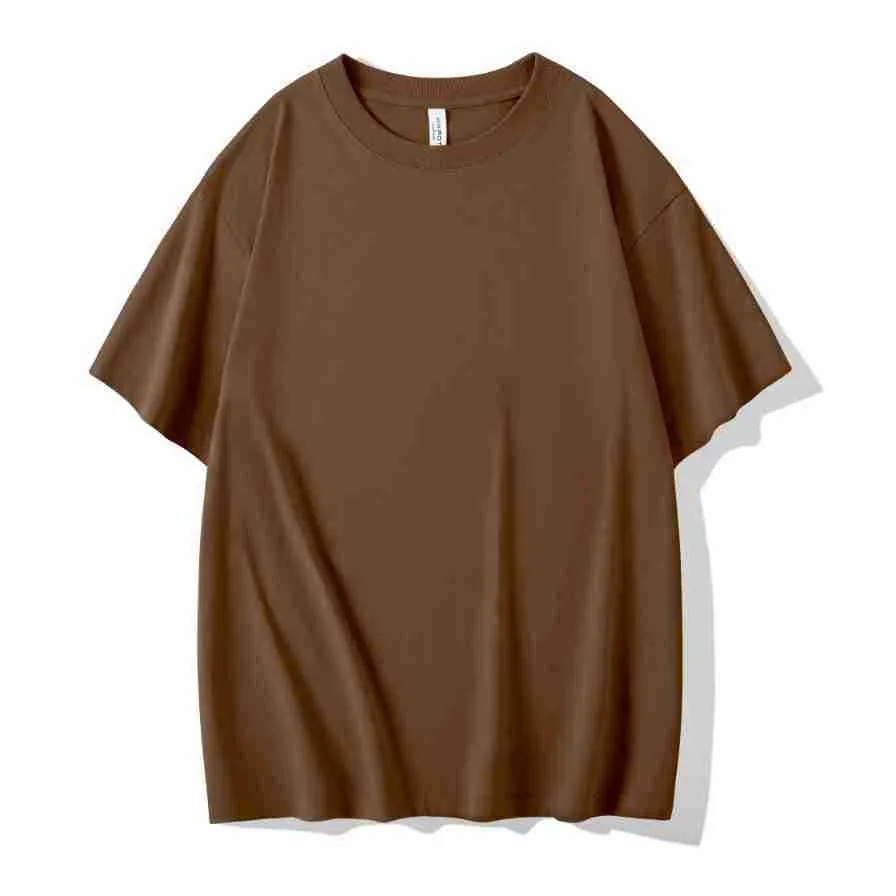 Man wearing a heavyweight dark grey drop shoulder T-shirt with layered shoulder detail.