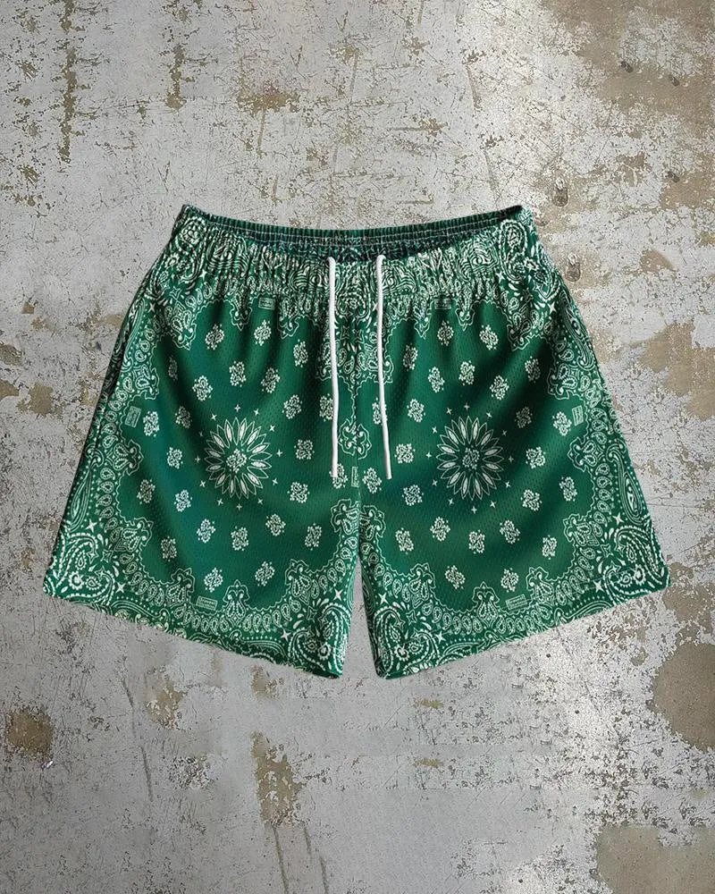 Man wearing loose blue digital print beach shorts made from quick-dry milk silk polyester fabric.