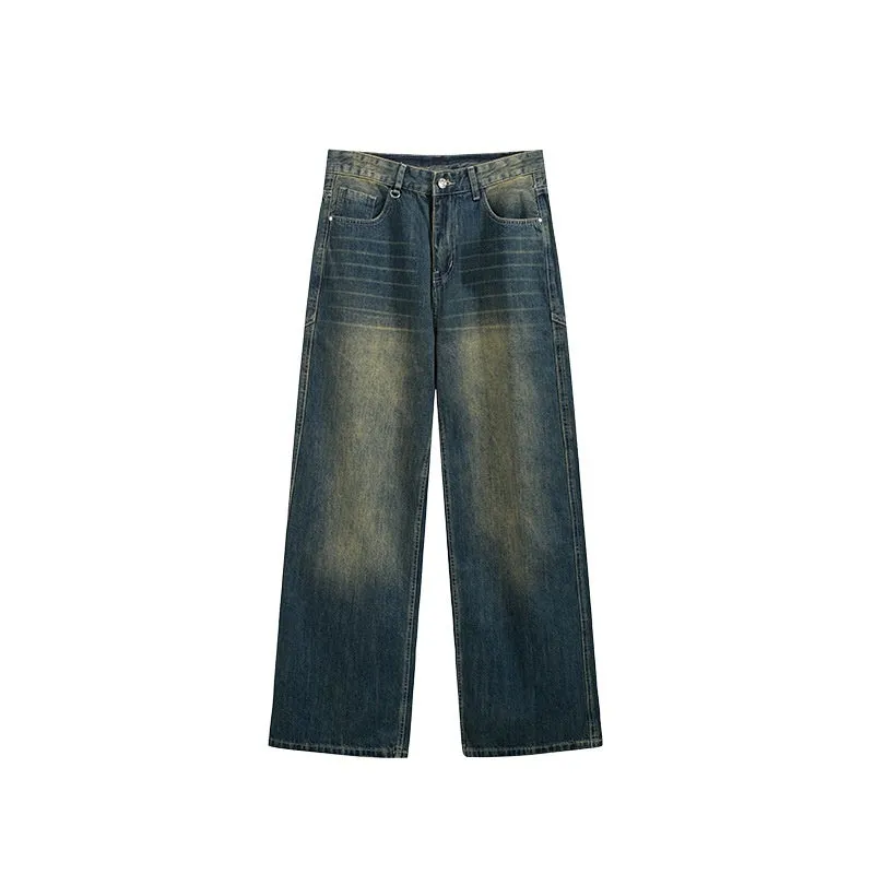 Man wearing washed blue wide leg straight-cut jeans with a mid waist and zipper fly.