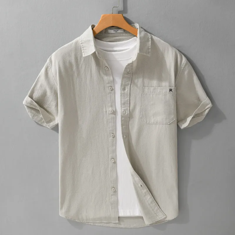 Men's light blue loose fit short-sleeved cotton shirt with a cardigan style front, laid flat.