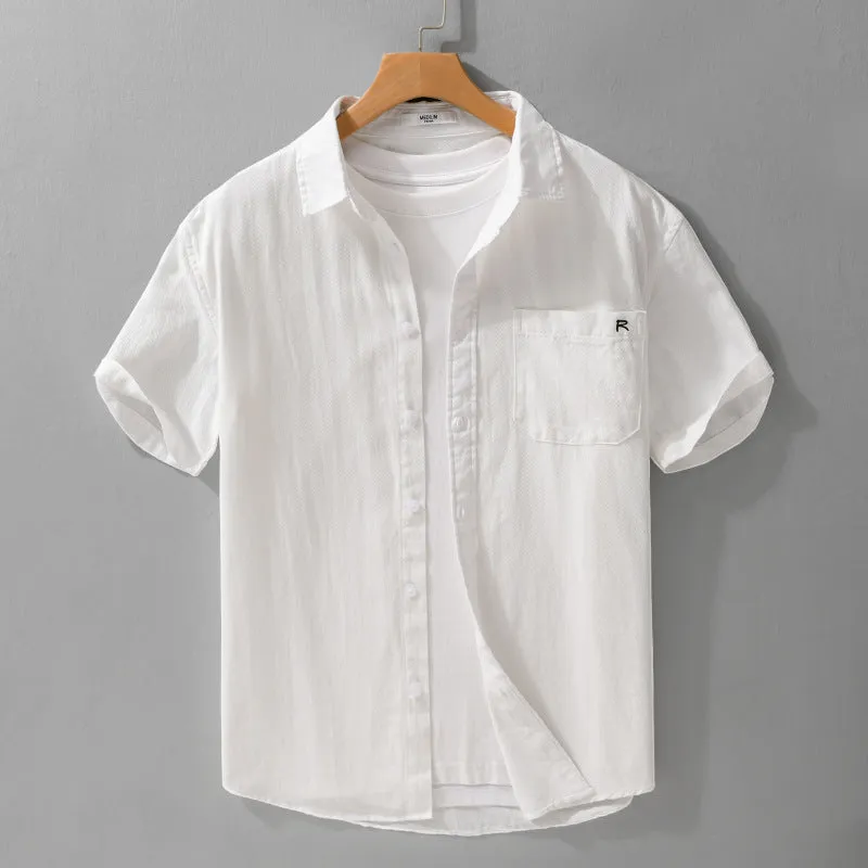 Men's light blue loose fit short-sleeved cotton shirt with a cardigan style front, laid flat.