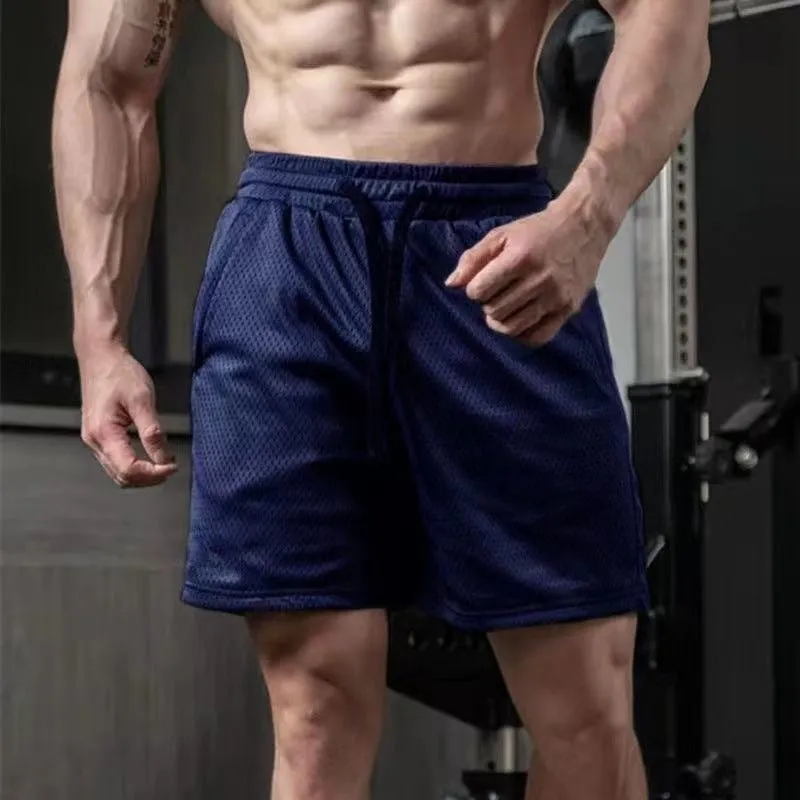 Man wearing light grey loose-fit mesh sport shorts with a straight leg cut.