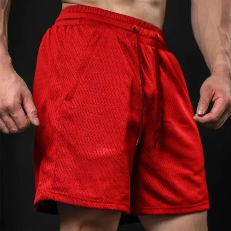 Man wearing light grey loose-fit mesh sport shorts with a straight leg cut.