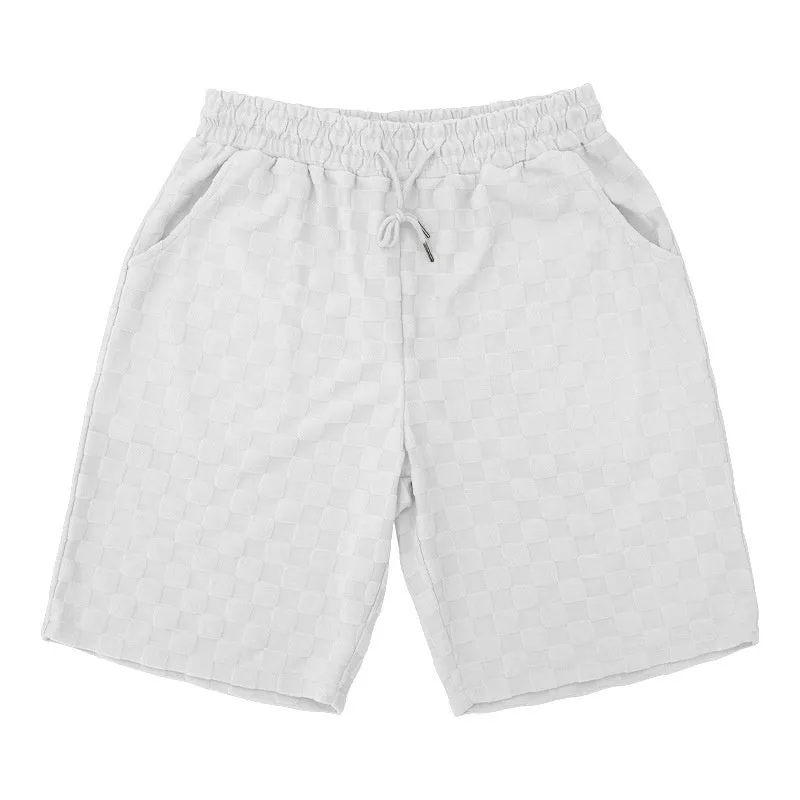 Men's black and white checkerboard plaid loose sports shorts with an elastic waistband.