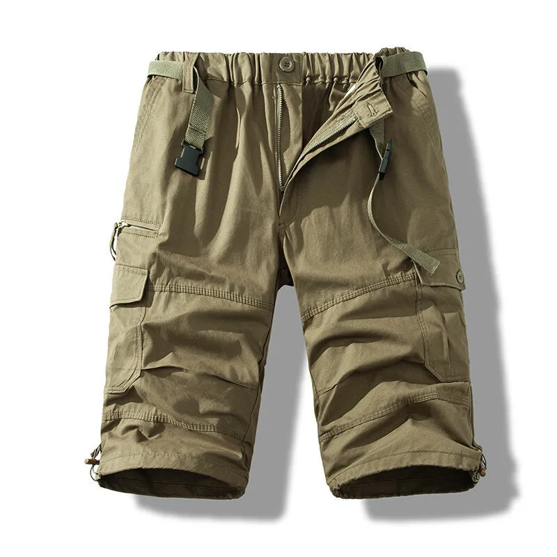 Men's cotton cropped overalls in army green, shown in a casual summer setting.