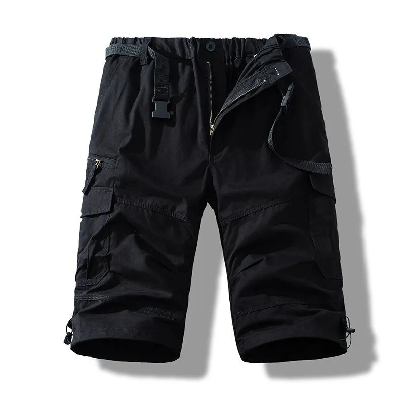 Men's cotton cropped overalls in army green, shown in a casual summer setting.