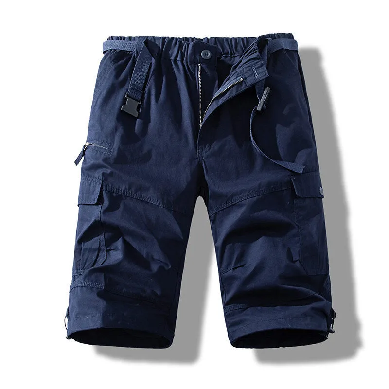 Men's cotton cropped overalls in army green, shown in a casual summer setting.
