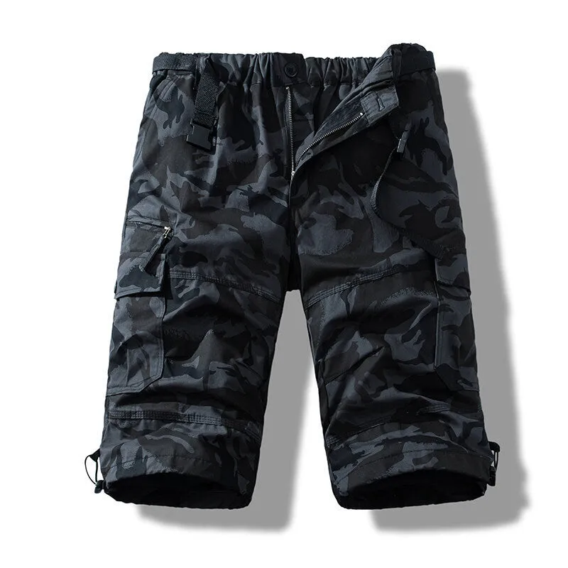 Men's cotton cropped overalls in army green, shown in a casual summer setting.