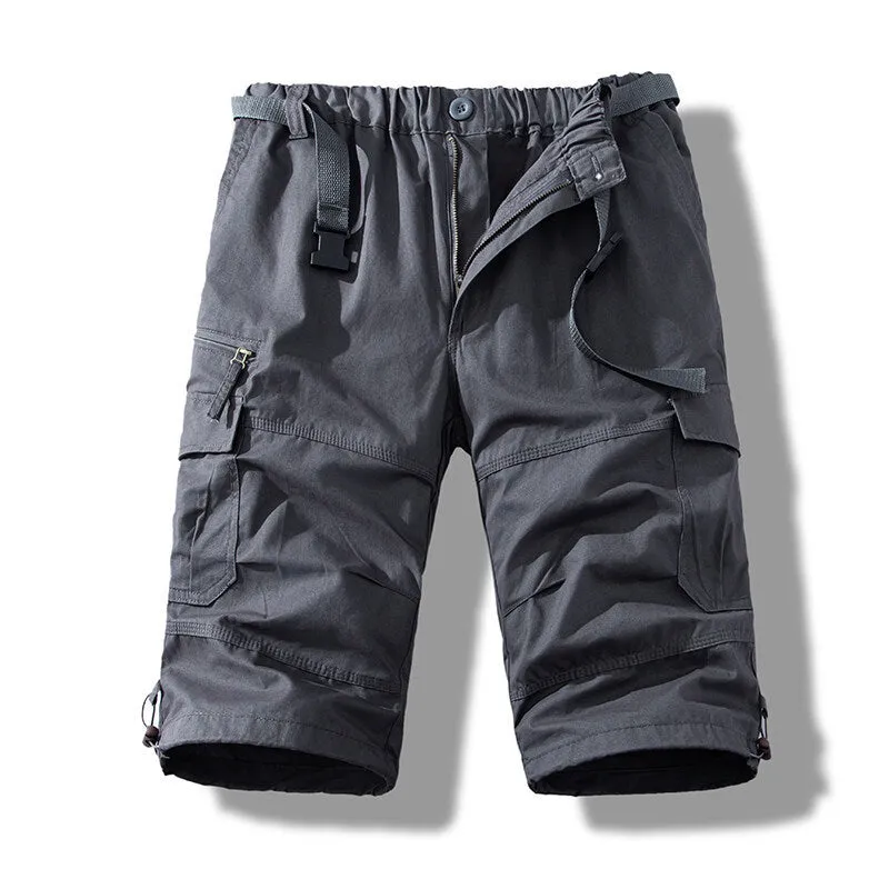 Men's cotton cropped overalls in army green, shown in a casual summer setting.