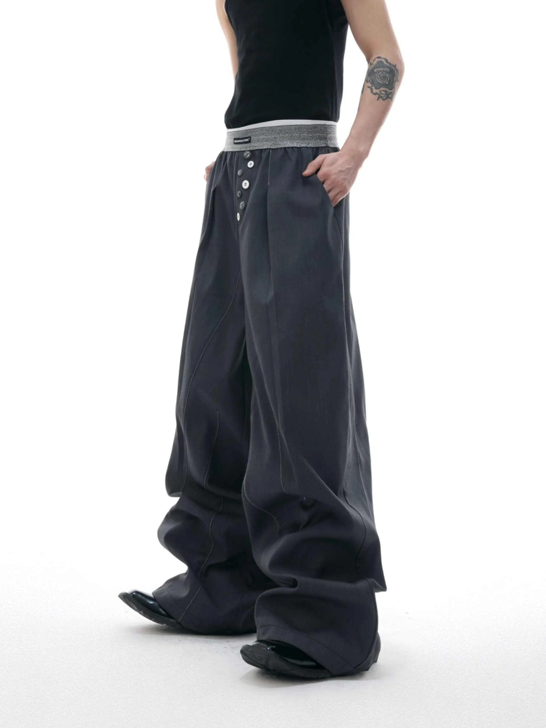 Straight-leg high-waisted trousers in grey fabric with button detail on the leg.