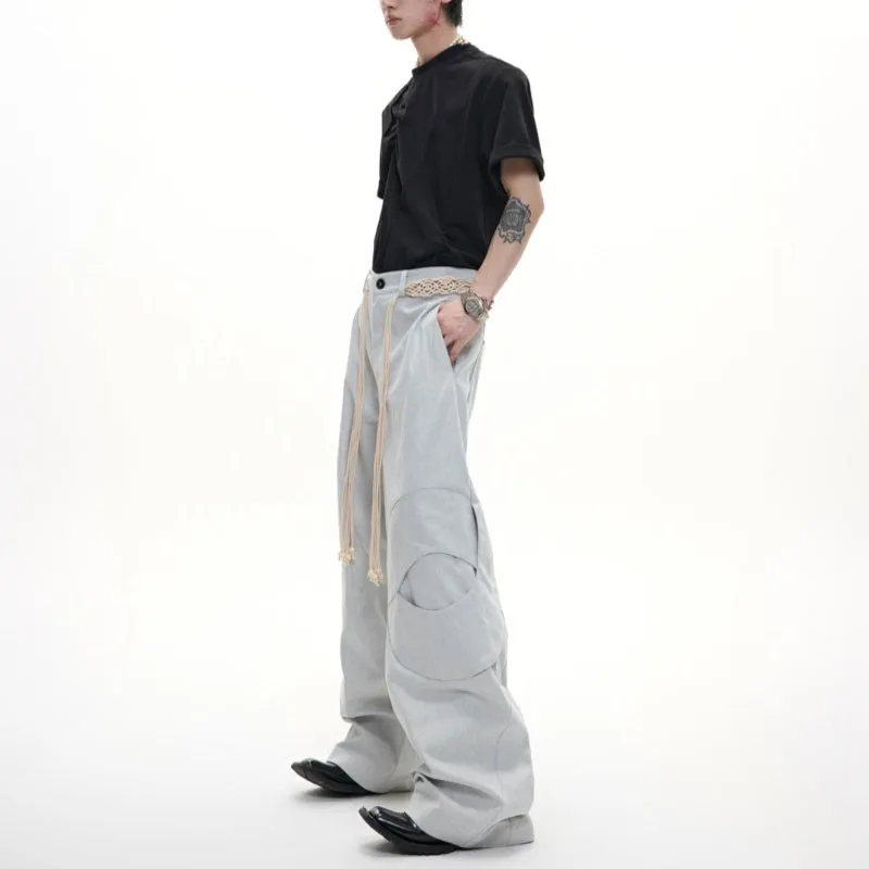 Man's dark blue straight-leg cotton trousers with belt stitching and zipper details on a loose fit.