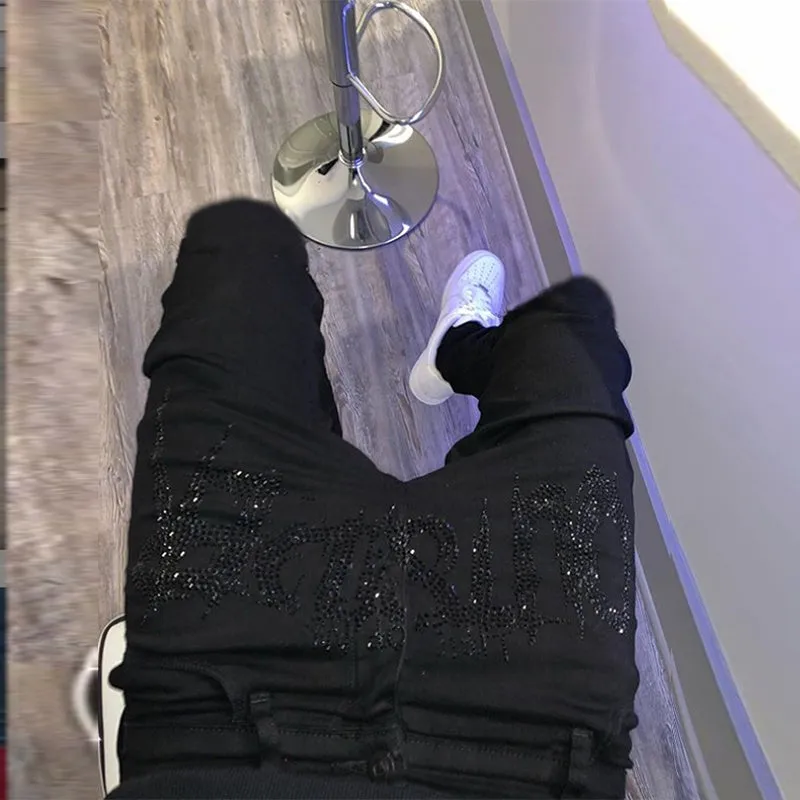 Men's black fashion ripped jeans with slim fit and distressed detailing, shown from front