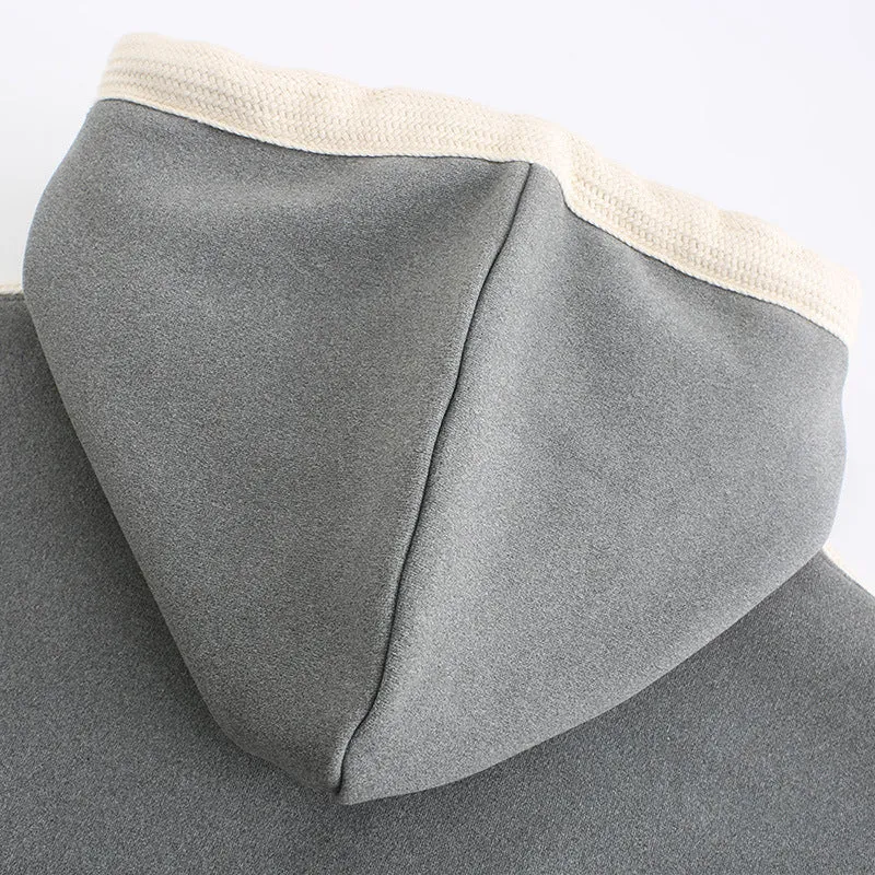 Women's USB heated jacket hoody in black, with brushed fabric and knitted construction, shown outdoors in cold weather