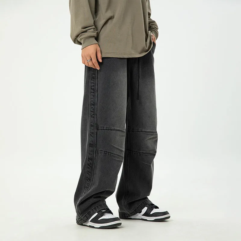 Pair of black pleated Japanese drawstring trousers lying flat showing loose-leg silhouette and drawstring waist
