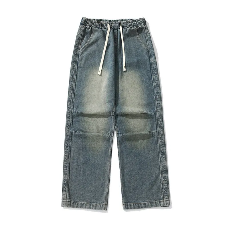 Pair of black pleated Japanese drawstring trousers lying flat showing loose-leg silhouette and drawstring waist
