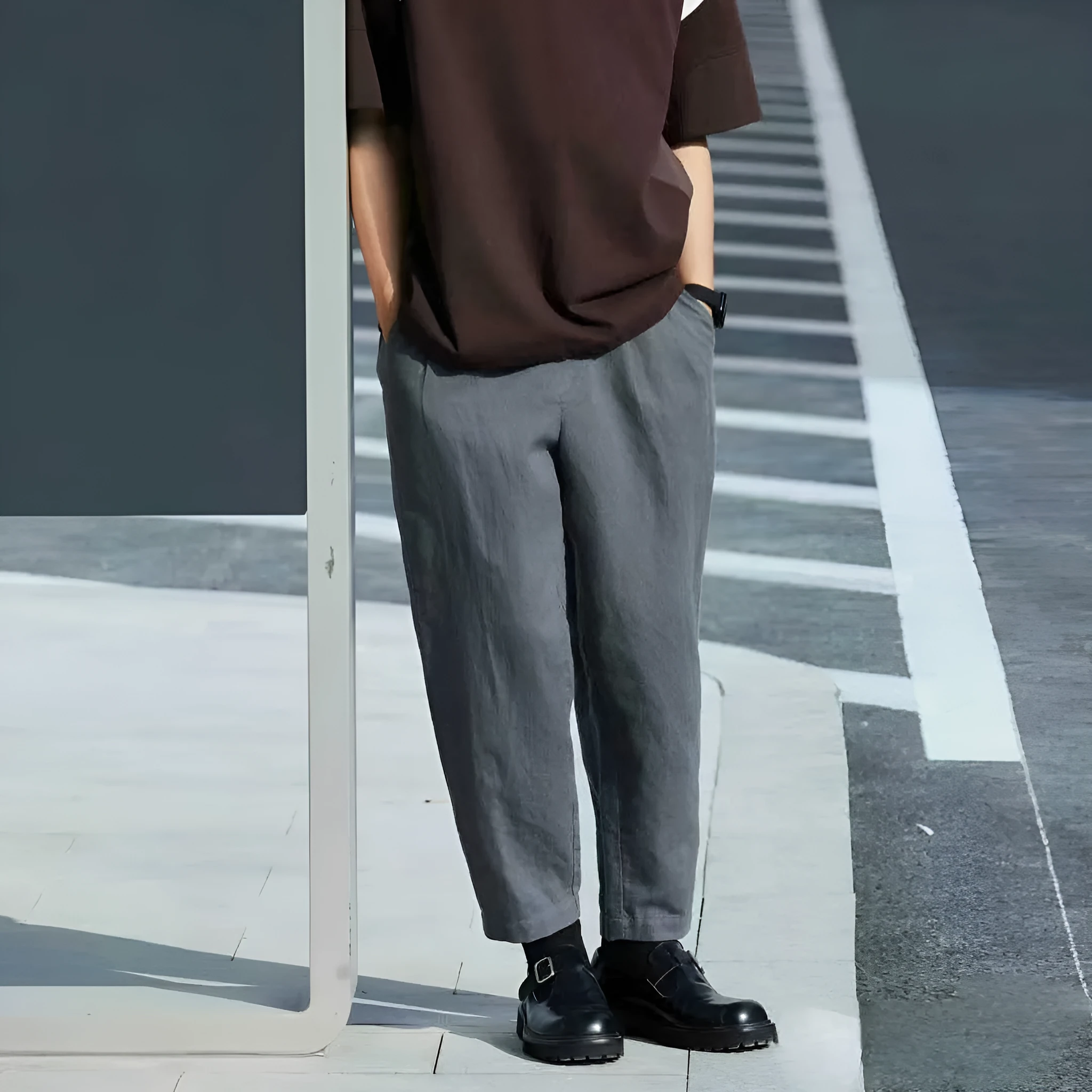 A man wearing beige loose straight-leg casual trousers with a drawstring waist.