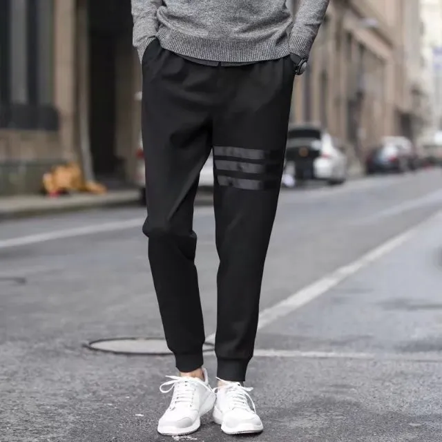 Men's casual slim sweatpants in black with elastic waistband and drawstring, side pockets, tapered leg, polyester fibre fabric