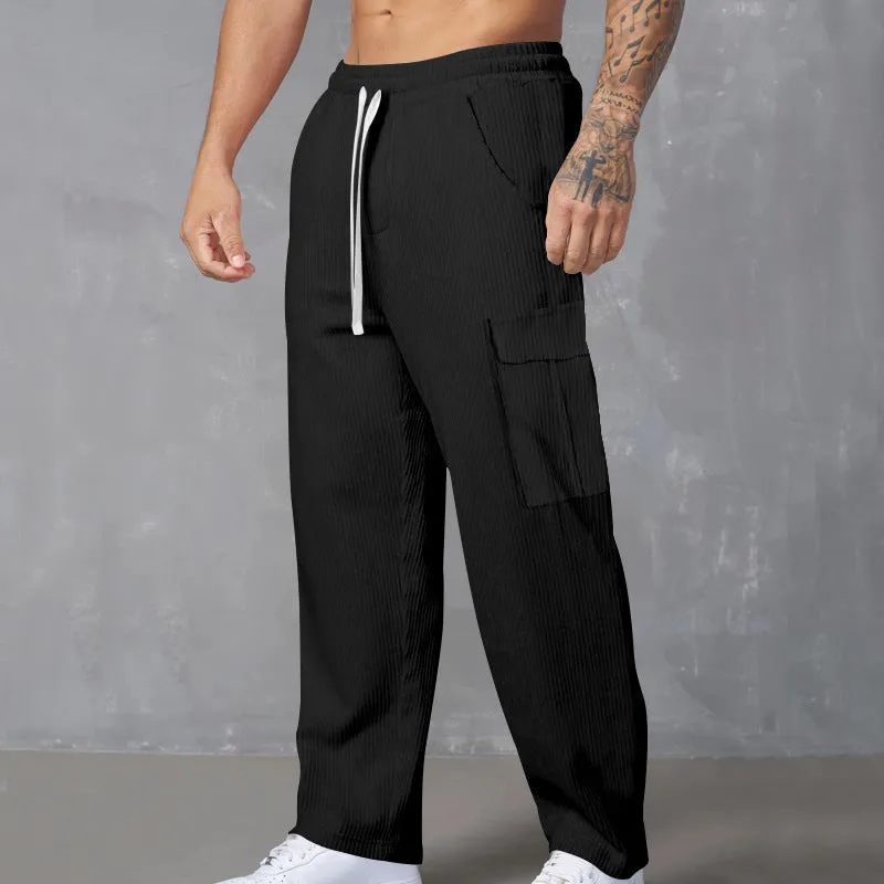 Men's navy blue corduroy wide-leg cargo trousers with a drawstring waist on a neutral background.