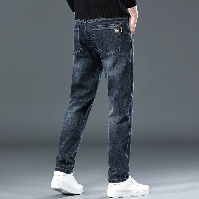 Blue grey men's slim straight casual trousers with a mid waist and zip fly on a neutral background.