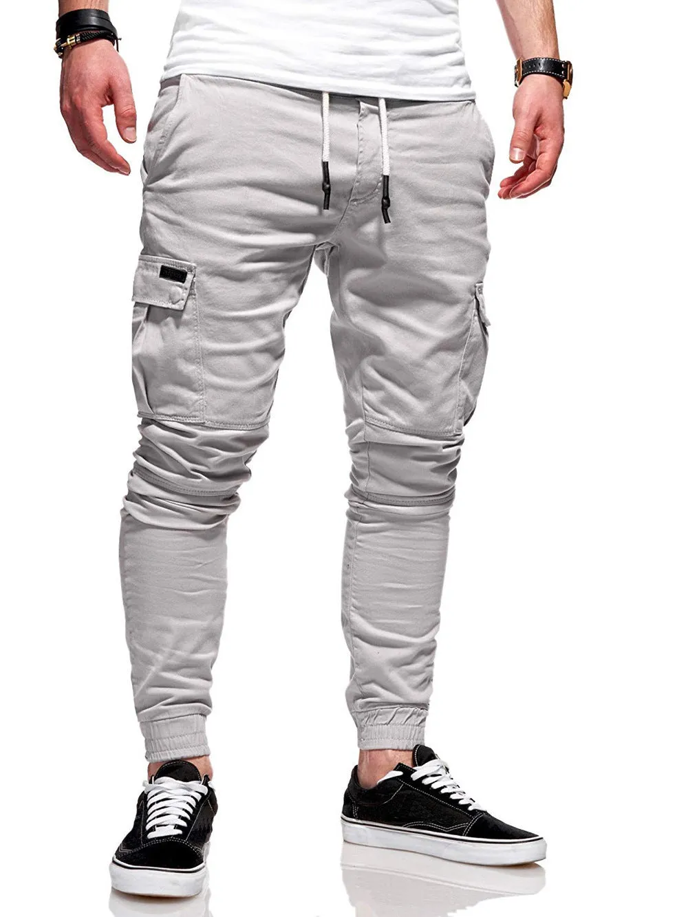Man wearing loose-fit light blue casual trousers with a patch pocket and elasticated lace waistband