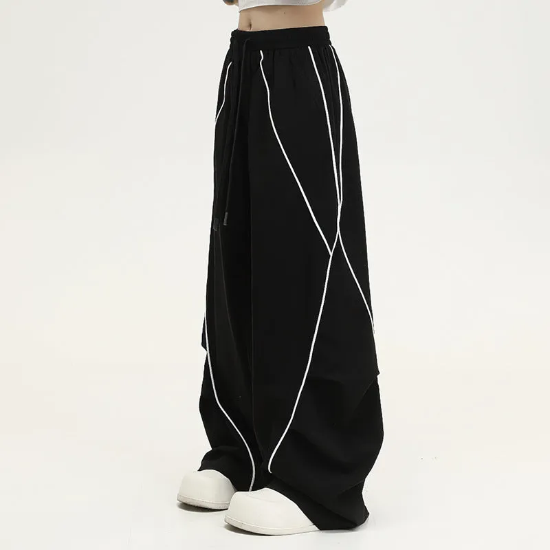 Black striped pleated wide-leg hip hop trousers laid flat, showing loose fit and mid waist.