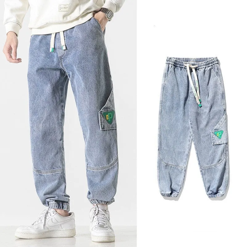 Men's black cotton loose-fit tapered trousers with a mid waist on a hanger.