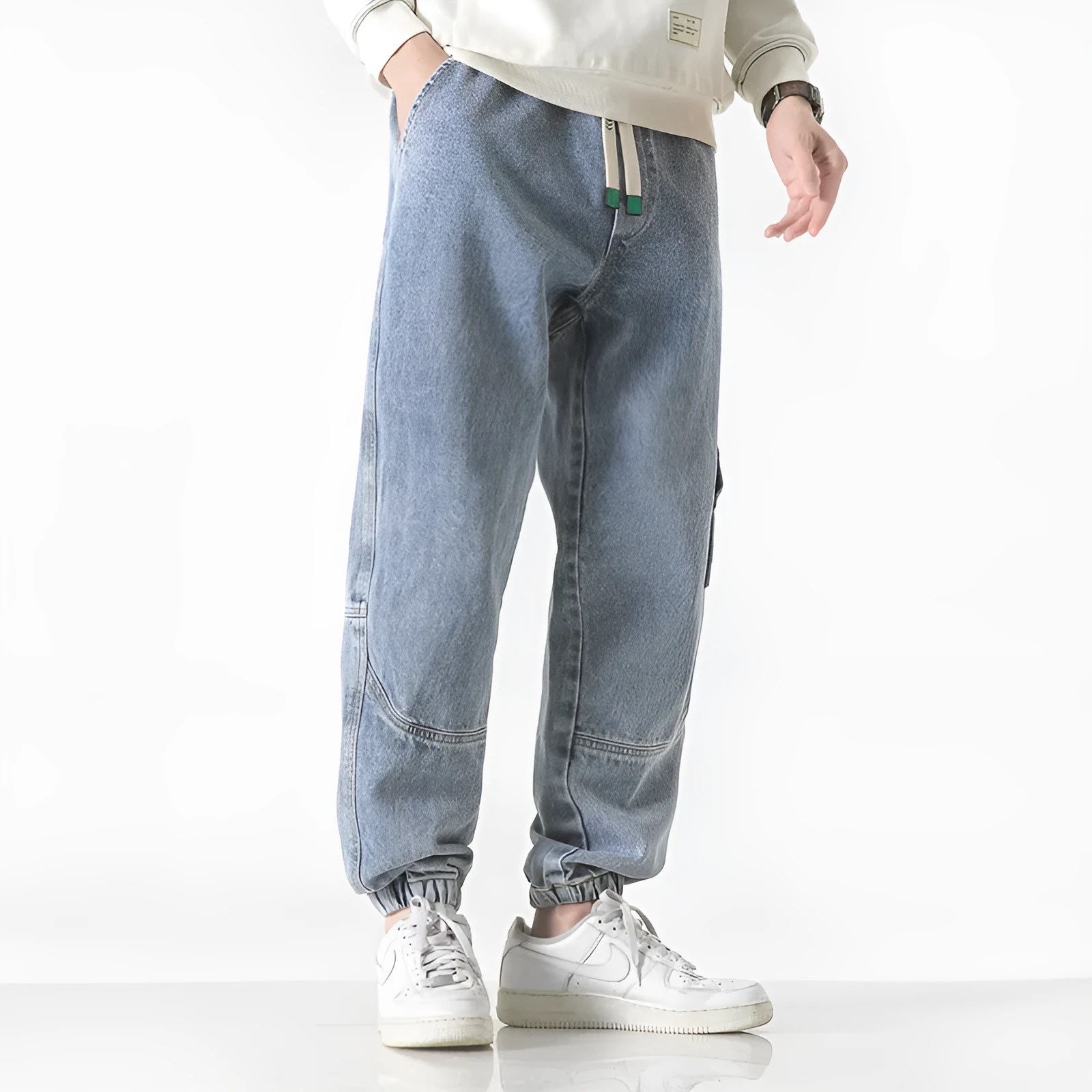 Men's black cotton loose-fit tapered trousers with a mid waist on a hanger.