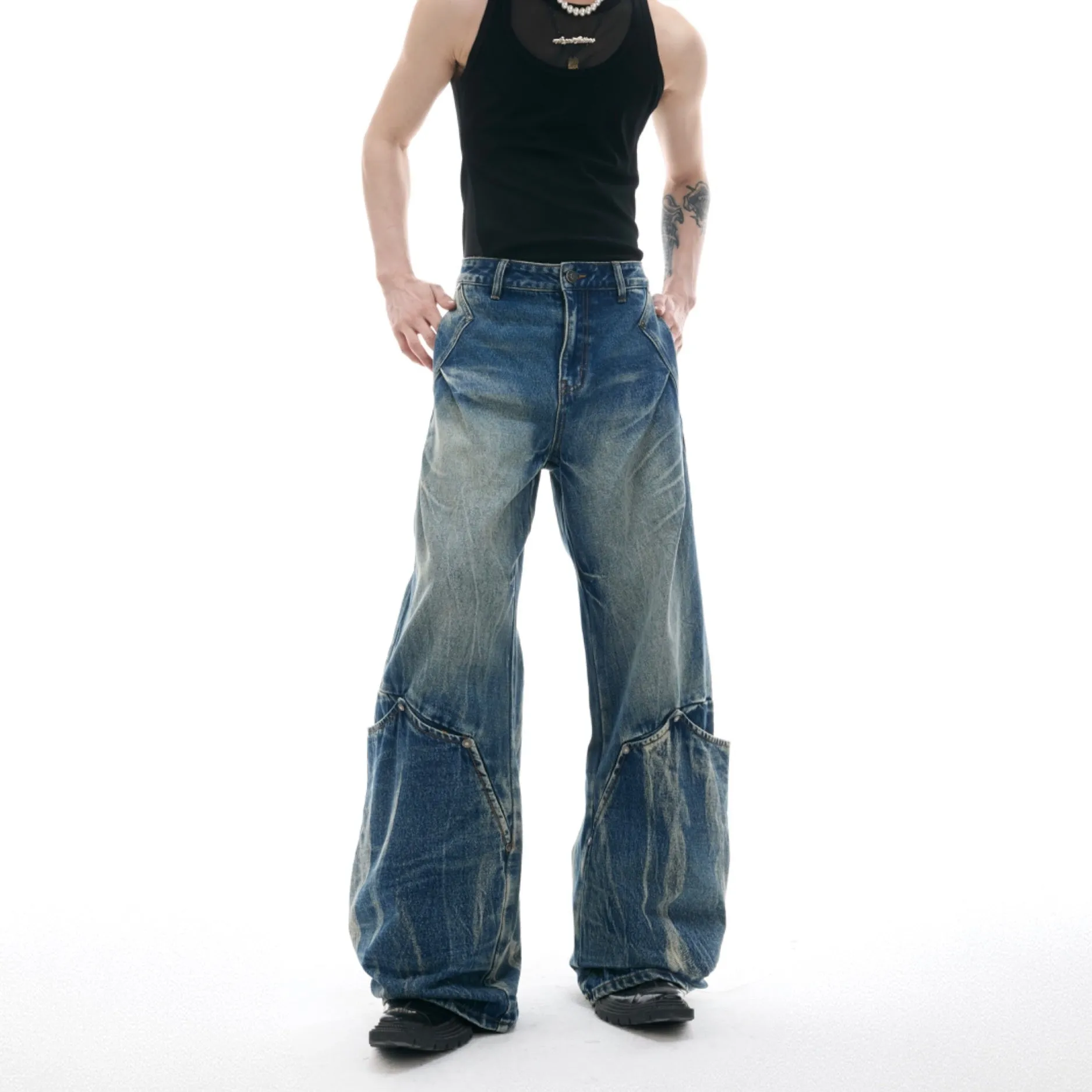 Man wearing verdant blue loose-fit retro jeans with a washed burst pattern.