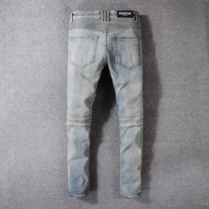 Grey biker jeans with straight tube leg, mid-rise waist, zipper fly, and distressed denim finish