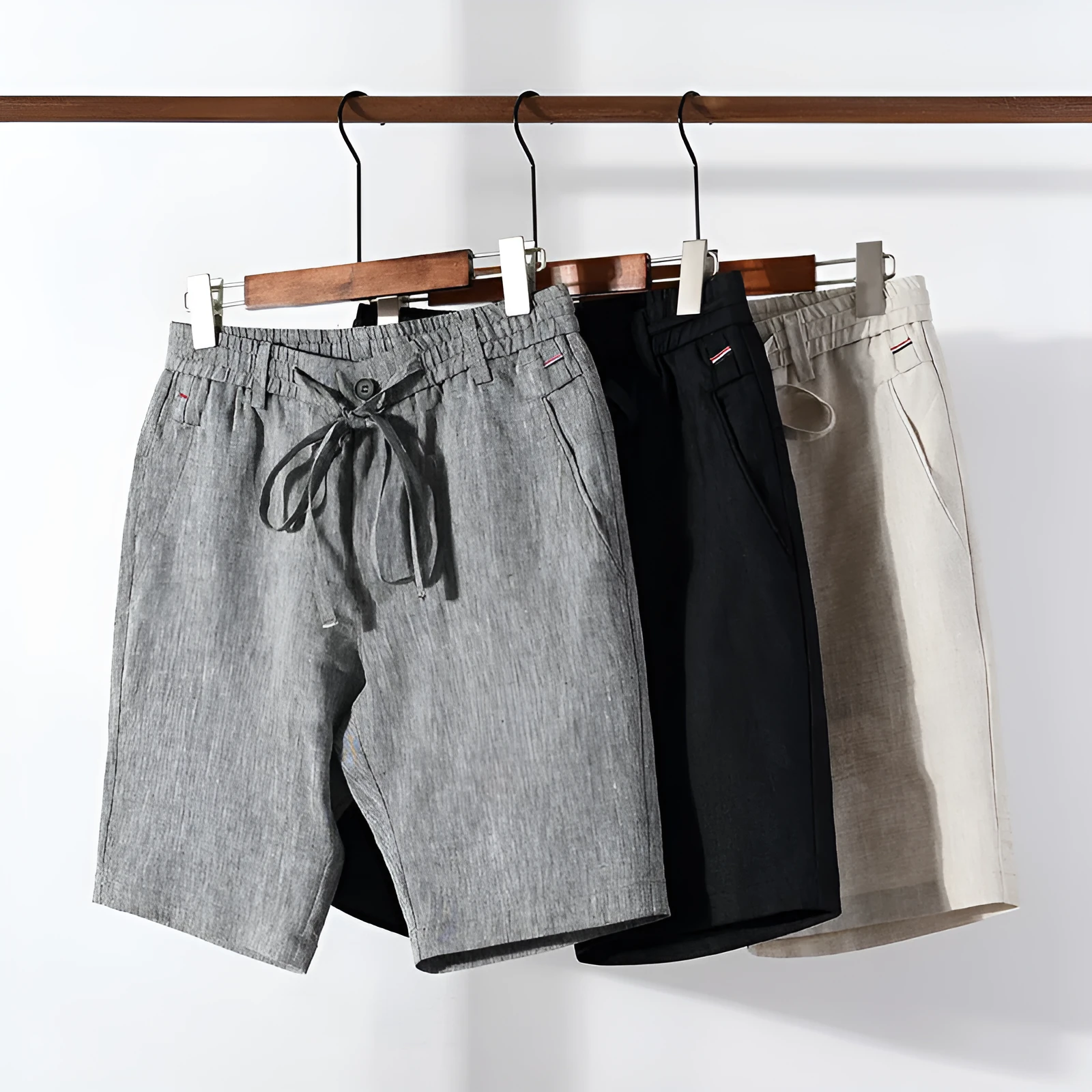 Men's 100% linen straight shorts in black, front view, mid-waist with zipper fly and pocket detail