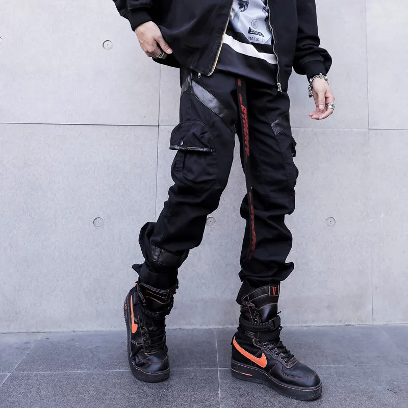 Black men's leather pocket splice cargo trousers with harem cut and long legs