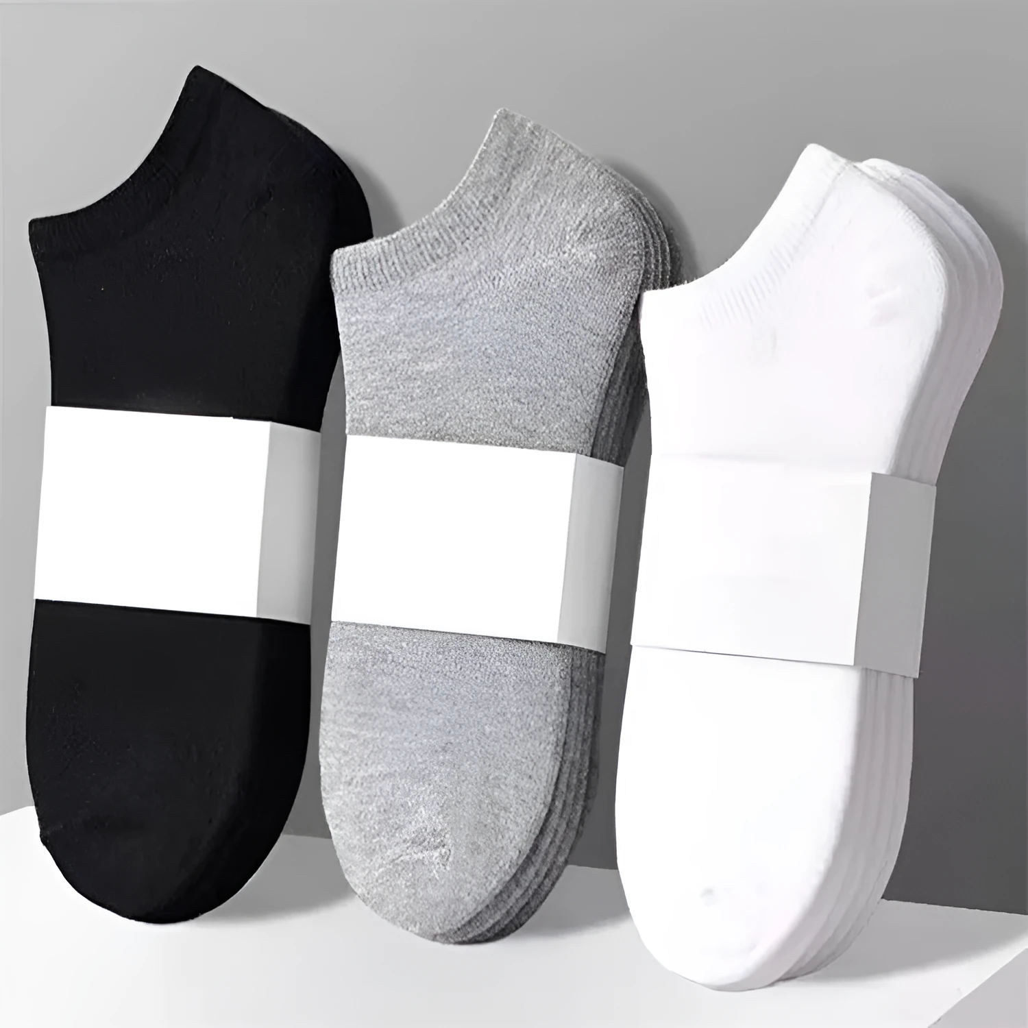Solid colour men's low cut socks in black, grey, and white with seamless toe construction and blended fabric for breathability.