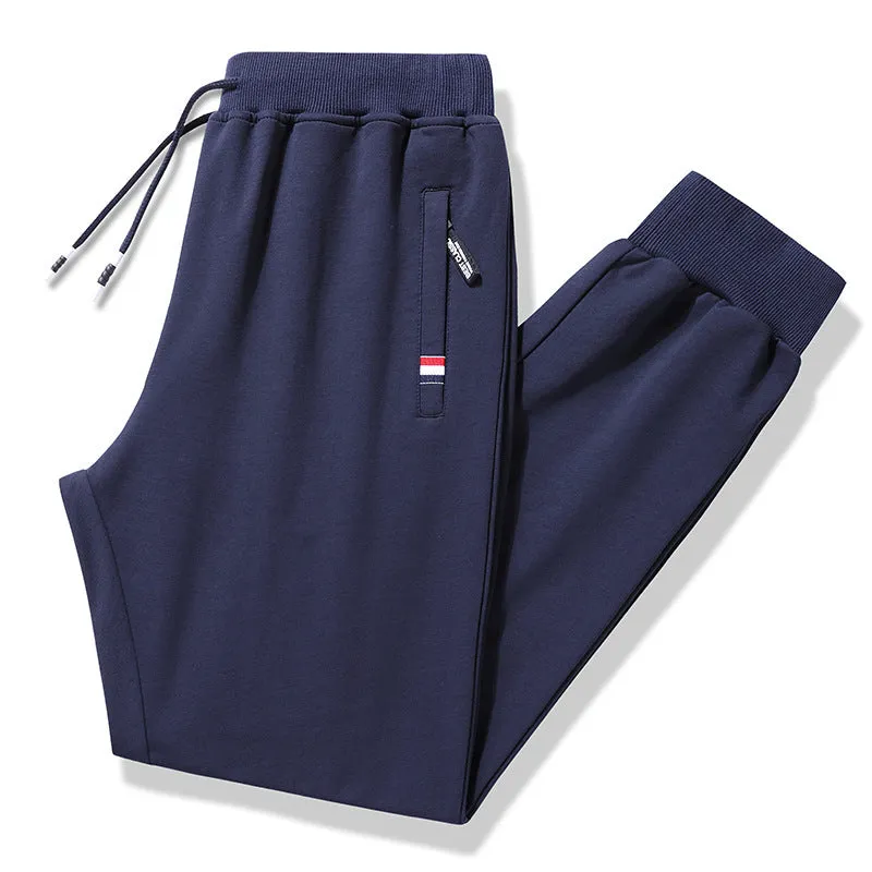 Pair of 95% cotton drawstring trousers in light grey, straight-leg nine-tenths length, laid flat on a plain background