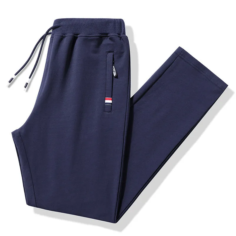 Pair of 95% cotton drawstring trousers in light grey, straight-leg nine-tenths length, laid flat on a plain background