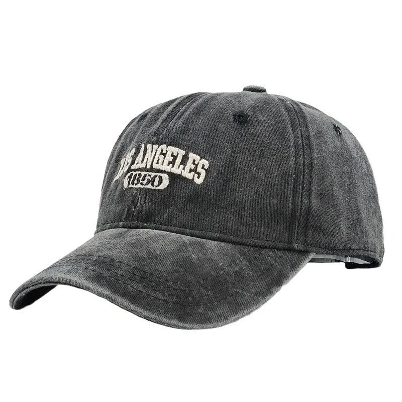Retro style acrylic peaked cap with distressed letter embroidery on the front, shown in beige colour.