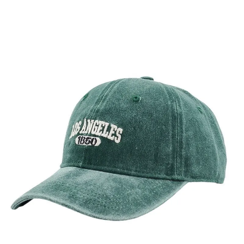Retro style acrylic peaked cap with distressed letter embroidery on the front, shown in beige colour.