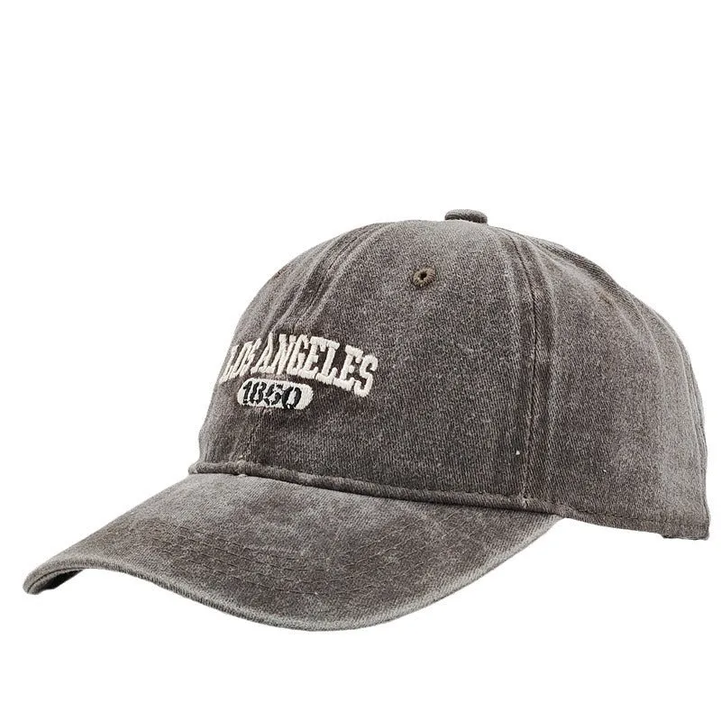 Retro style acrylic peaked cap with distressed letter embroidery on the front, shown in beige colour.