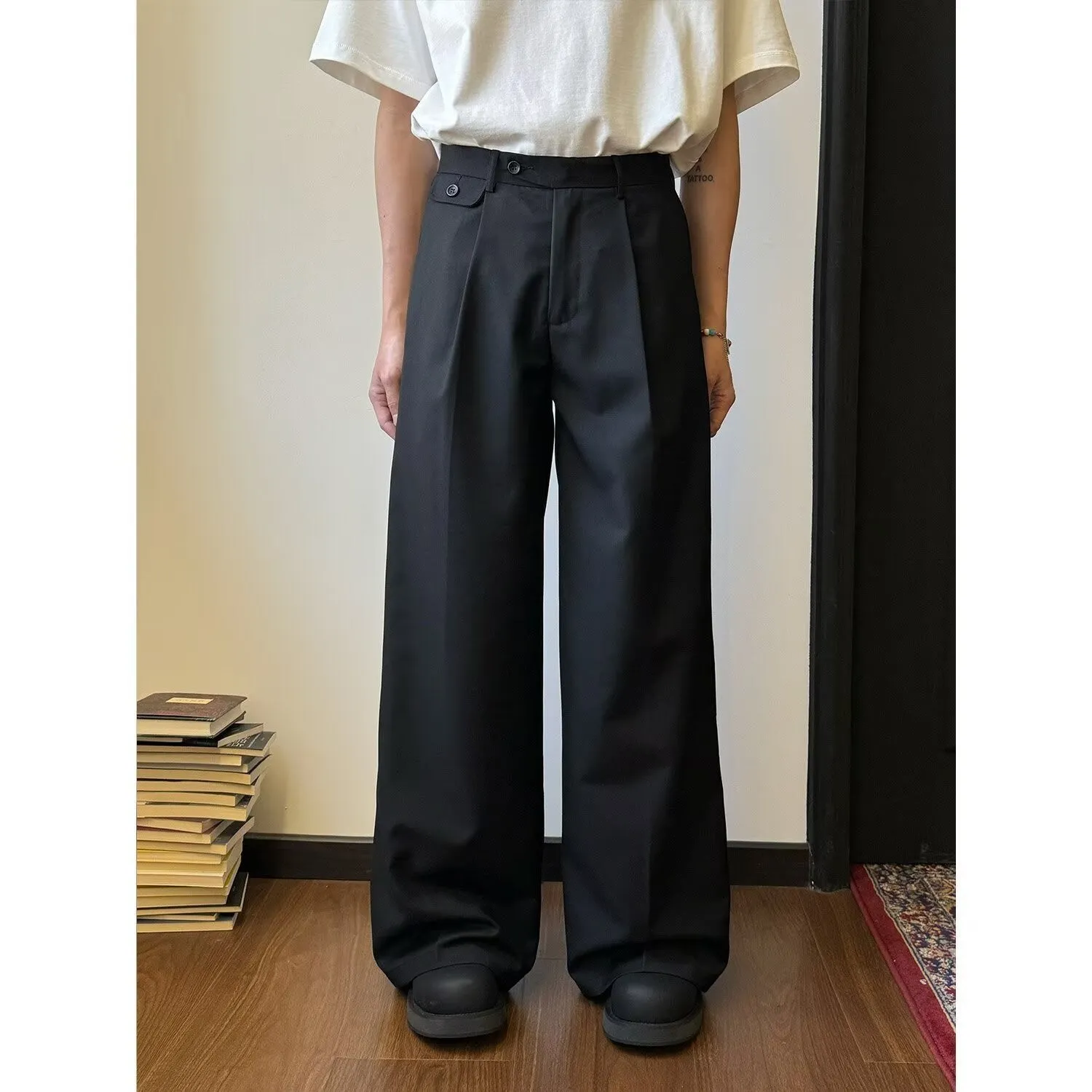 Men's straight-leg wide-leg casual trousers in black, showing loose fit and draping fabric.