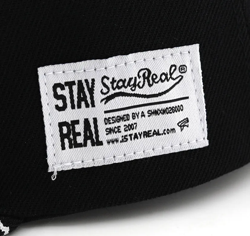 Black cotton baseball cap with white embroidered lettering on the front, showing adjustable back strap.