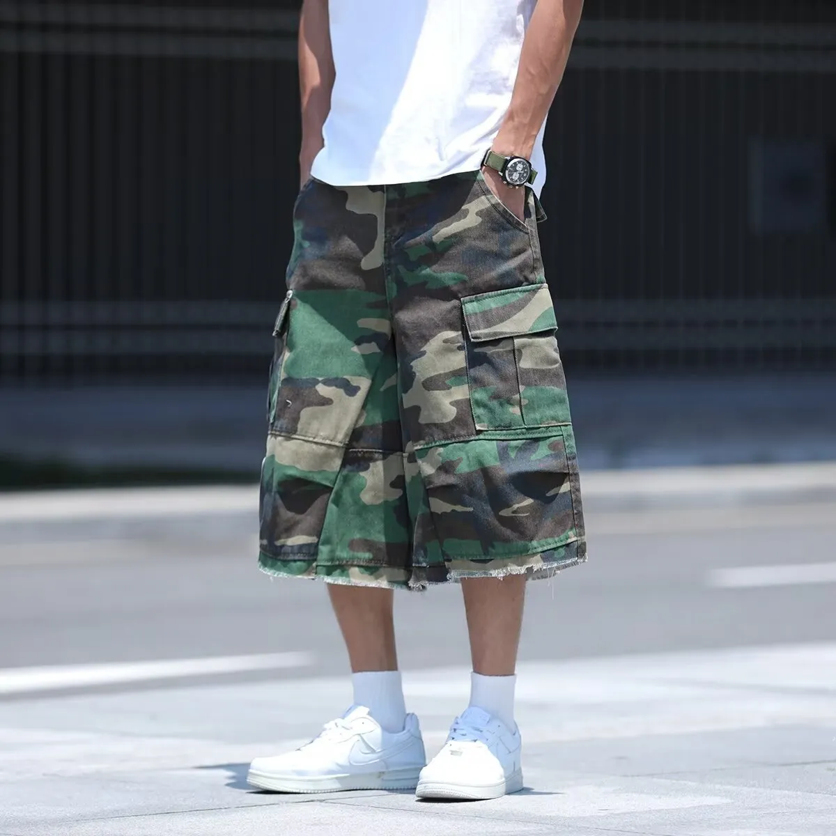 Man wearing loose, cropped camouflage shorts in a khaki colourway, showcasing the summer workwear style.