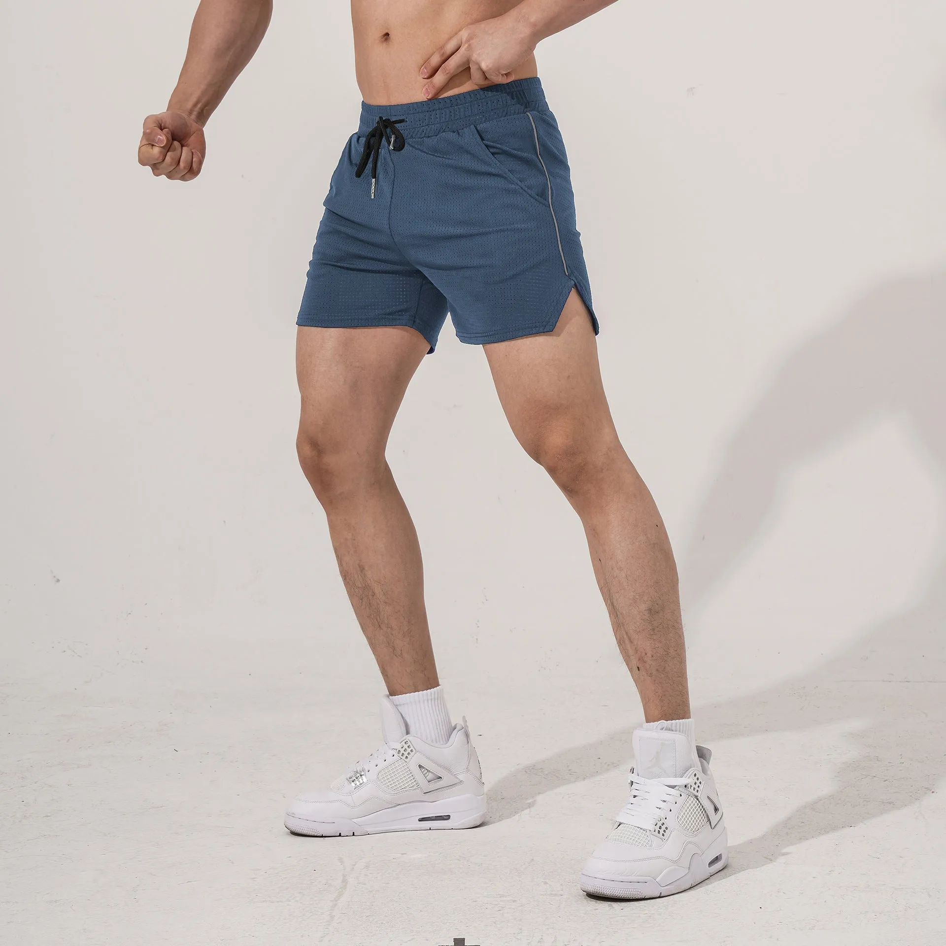 Man wearing straight-cut black polyester fitness shorts for sports and casual activities.