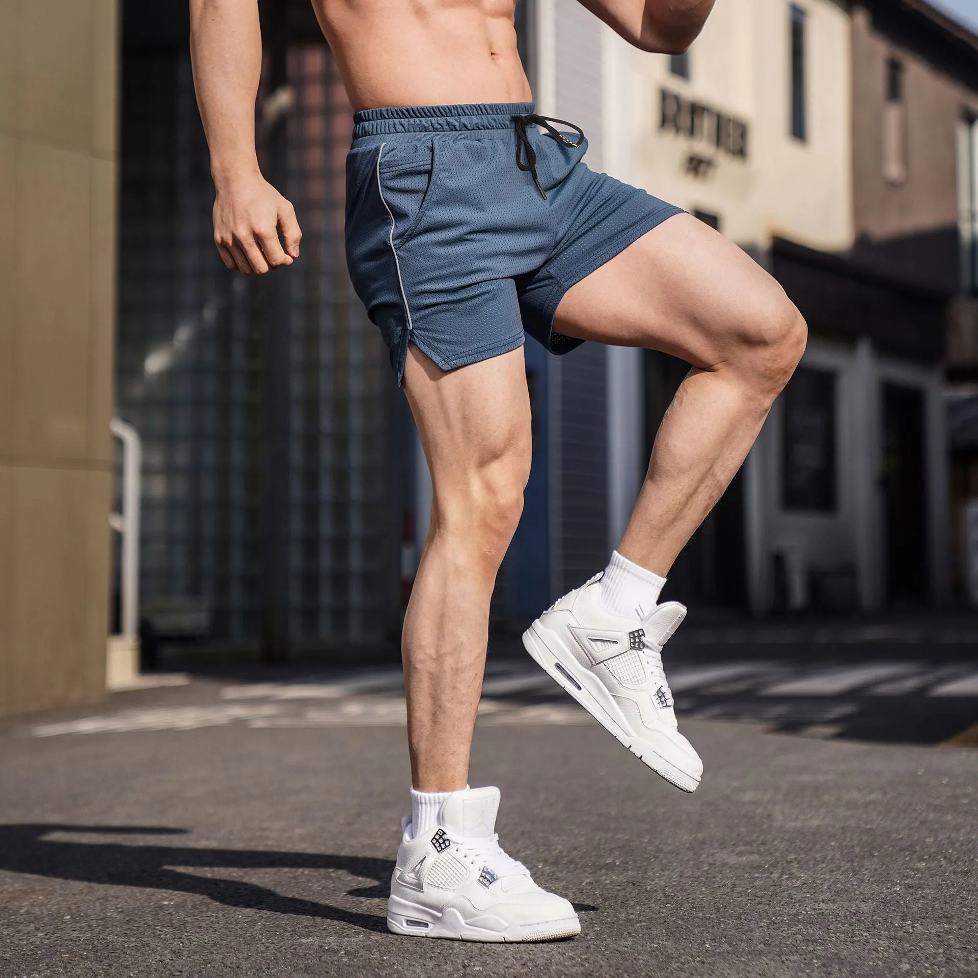 Man wearing straight-cut black polyester fitness shorts for sports and casual activities.