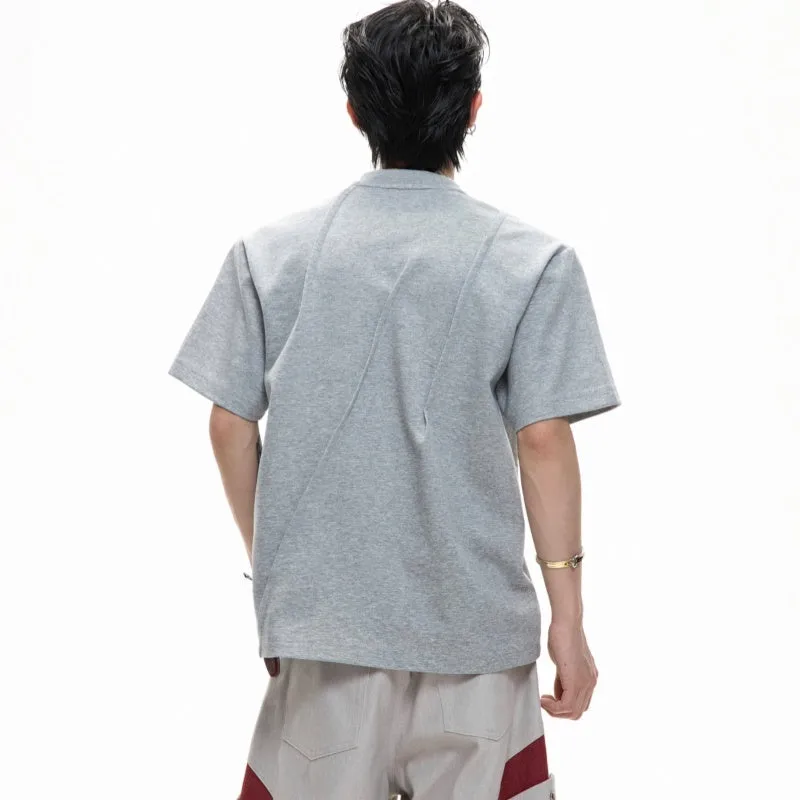 Men's loose black cotton T-shirt with textured pleats and asymmetric design detail.